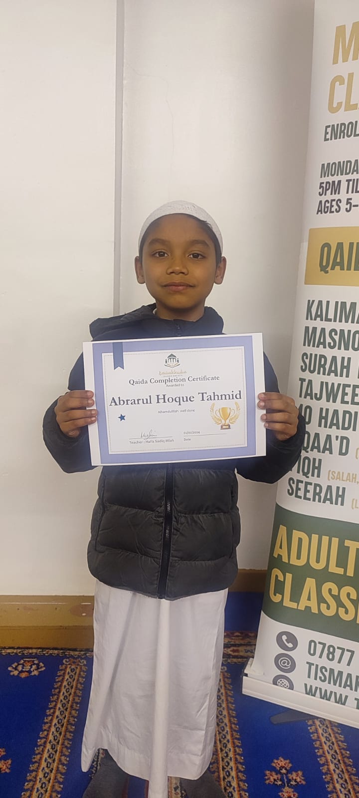 Maktab student with his Qaida completion certificate